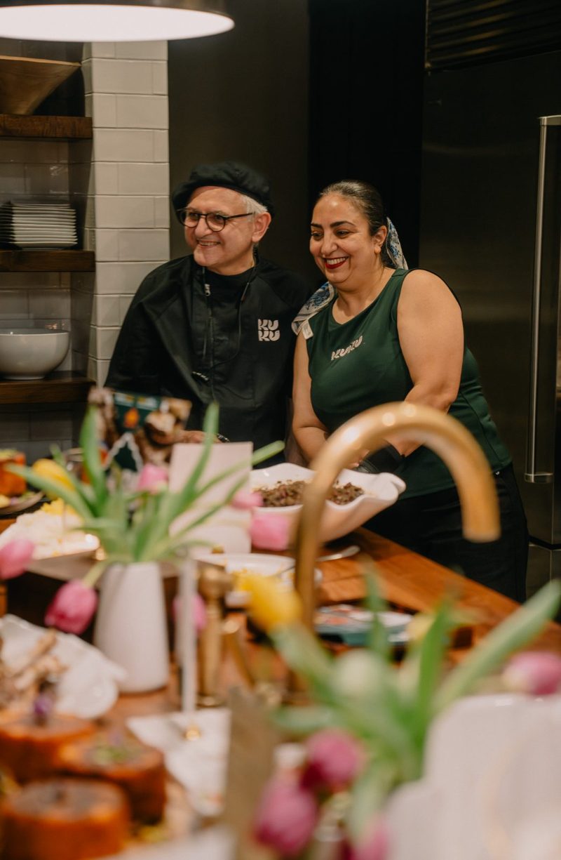 Reza and Shahla laughing behind the counter at KUKU